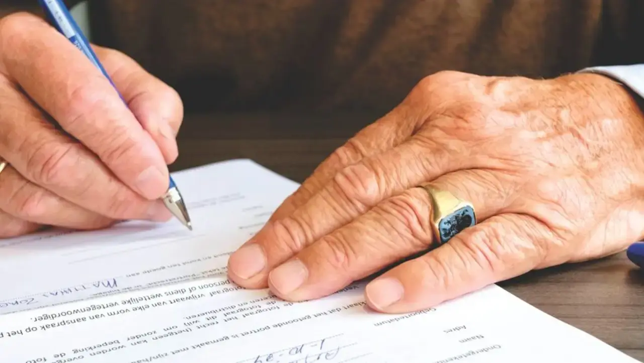 A senior person signing a will document